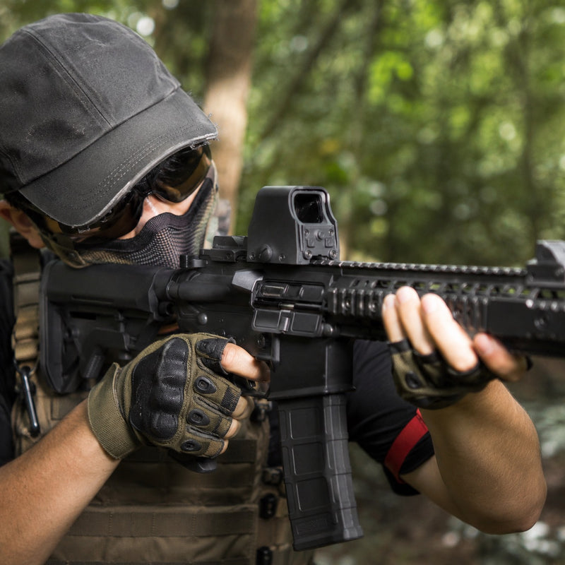 Airsoft-Spieler mit Leuchtpunktvisier auf einer M4 im Wald