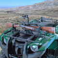 Doppelkralle Waffenhalter am ATV-Gepäckträger mit montiertem Gewehr im Gelände