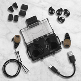 HD-30 Ersatzteile-Set, Ladecase mit Im-Ohr-Hoergeraeten, Ohrpassstuecken und USB-Ladekabel auf Marmoruntergrund
