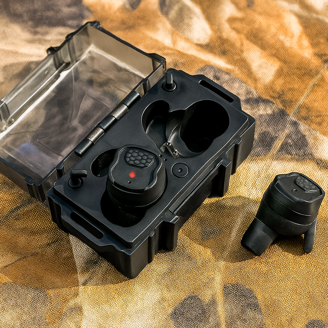 HD-30 Pro Gehörschutz, offene schwarze Box mit zwei Ohrhörern und einzelnem Ohrhörer auf Tarnmuster-Stoff