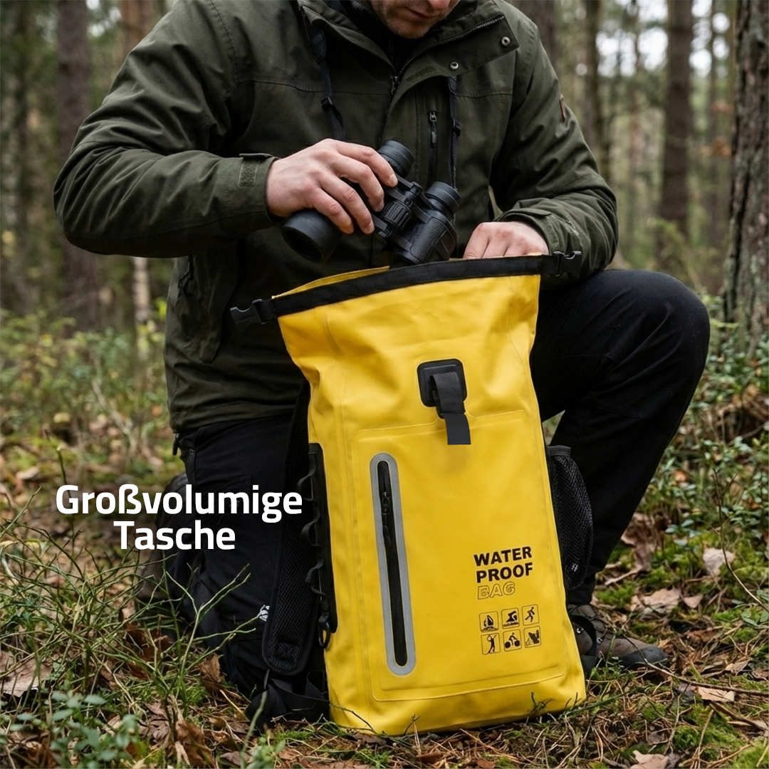 Jagdstrom gelber Rolltop-Rucksack im Laub, Jäger kniet davor und hält ein Fernglas