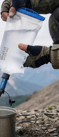Reinfluss Wasserfilterbeutel beim Befüllen eines Bechers in den Bergen
