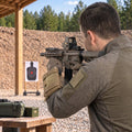 Datenwerk Schießdaten-Armtasche in Coyote am Unterarm, Schütze zielt von hinten mit Gewehr