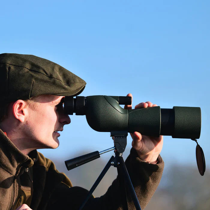 ZoomMeister Spektiv, Nahaufnahme Jäger beim Beobachten vor blauem Himmel, Objektivdeckel hängt locker