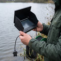 Angler haelt den Tiefblick Monitor am Wasser
