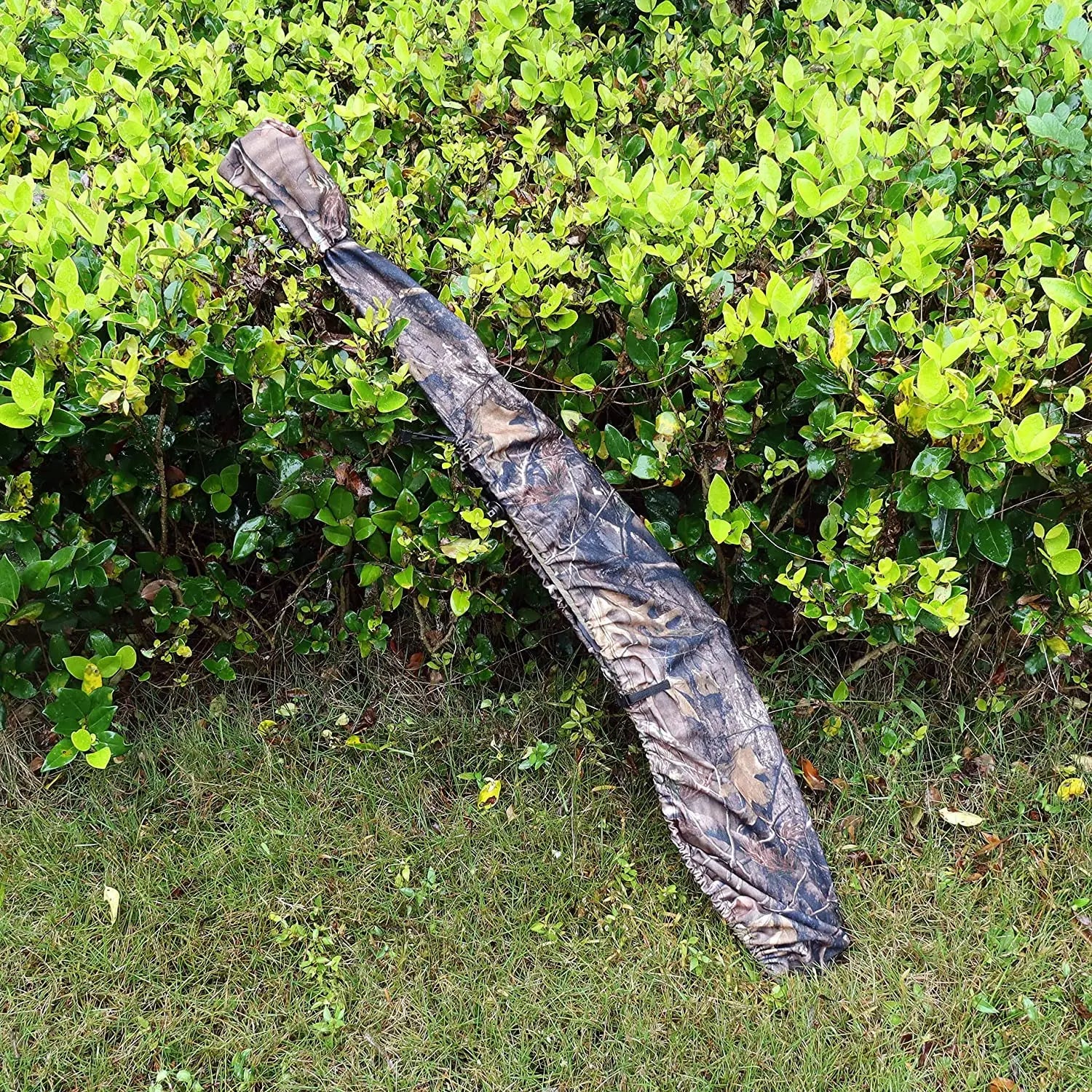 JagdPro Gewehrhülle im Camouflage-Muster, im Freien auf Wiese vor grüner Hecke drapiert